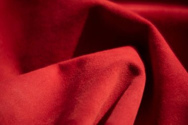 Süet kumaşın kırmızı mat arka planı, yakın plan. Pürüzsüz deri kadife desenli. Keçeleşmiş makro. Kırmızı süet kumaş. Kumaş, deri, tasarımcılar için malzeme..
