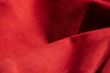 Süet kumaşın kırmızı mat arka planı, yakın plan. Pürüzsüz deri kadife desenli. Keçeleşmiş makro. Kırmızı süet kumaş. Kumaş, deri, tasarımcılar için malzeme..