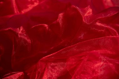 Organza kırmızısı. Soyut arkaplan kırmızı şifon organza. doku arkaplan deseni kırmızı ipek kumaş. Bu ipek organzanın açık bir dokuması var..