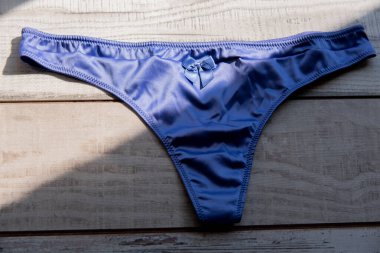 Tanga. Mor tanga iç çamaşırı. Kadın, beyaz ya da morun altındadır. Mahrem kadın şeyleri..