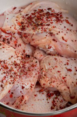 Taze derisi olmayan tavuk butları. Çiğ tavuk budu. Çiğ tavuk budu. Baharatlı tavuk eti tavada kırmızı biber..