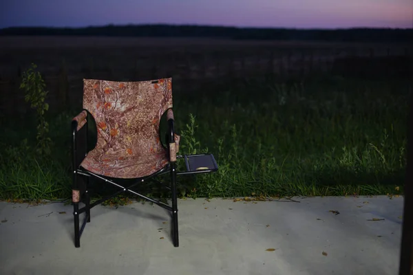 Empty Camping Chair In The Field. Chair in the relaxation field. Camping, solitude with nature, downshifting