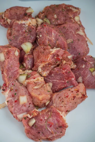 Kebab - pieces of pork and chopped onion, photographed close-up. Pork chopped into pieces on a barbecue with onions. Raw pork in spices, pickled meat. Preparation for the preparation of meat dishes