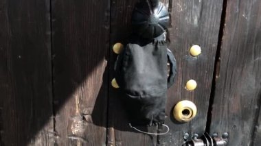 Ev yapımı siyah maske bir evin kapı kolunda asılı. Dış kapıda bir tıbbi maske asılı. Kapı tokmağında asılı koruyucu maske, karantina konsepti, koronavirüs mirovach salgını.