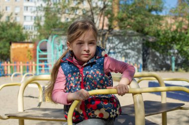 Oyun parkında sevimli küçük bir kız. Çocuk parkındaki küçük kız. Şirin küçük kız parkta eğleniyor. Aktif küçük kız. Portre