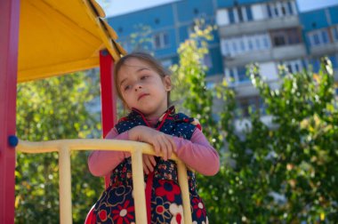 Oyun parkında sevimli küçük bir kız. Çocuk parkındaki küçük kız. Şirin küçük kız parkta eğleniyor. Aktif küçük kız. Portre