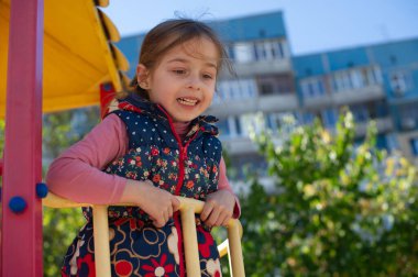 Oyun parkında sevimli küçük bir kız. Çocuk parkındaki küçük kız. Şirin küçük kız parkta eğleniyor. Aktif küçük kız. Portre