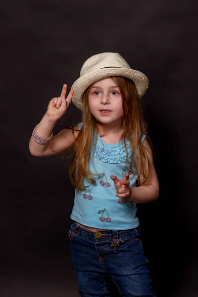 아름다운 소녀는 표현을 있습니다 치켜들었습니다 청바지를 배경의 어린이의 모자쓴 말이야 — 스톡 사진