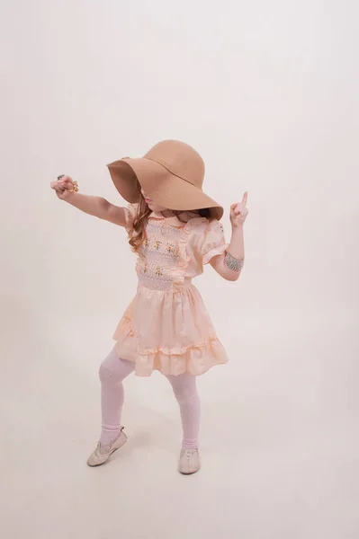 ドレス姿の可愛い女の子 研究室で帽子とドレスの女の子 子供の感情 — ストック写真