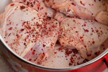 Taze derisi olmayan tavuk butları. Çiğ tavuk budu. Çiğ tavuk budu. Baharatlı tavuk eti tavada kırmızı biber..