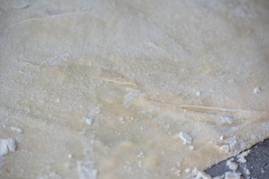 Çiğ sarı İtalyan makarnası. Ev yapımı erişte pişirme işlemi. Ev yapımı erişte. Un, su ve yumurtalı hamur. Pişirme un ürünleri.