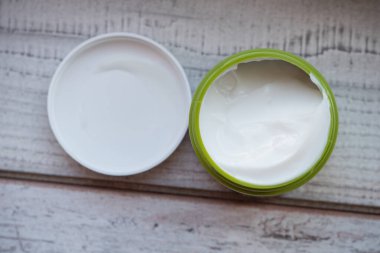 Aloe vera merhem merhemi, merhem, yüz kremi ya da saç maskeli küçük yeşil bir kavanoz. Doğal güzellik titremeleri ve spa. Üst Manzara. Tahta bir arka planda yeşil bir kavanozda saç maskesi