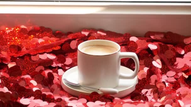 赤い輝きを背景にコーヒーとホワイトカップ 赤い輝く背景を背景にしたドリンクグラスでコーヒーを間近に眺めることができます 赤い背景にエスプレッソ モーニングコーヒー — ストック動画