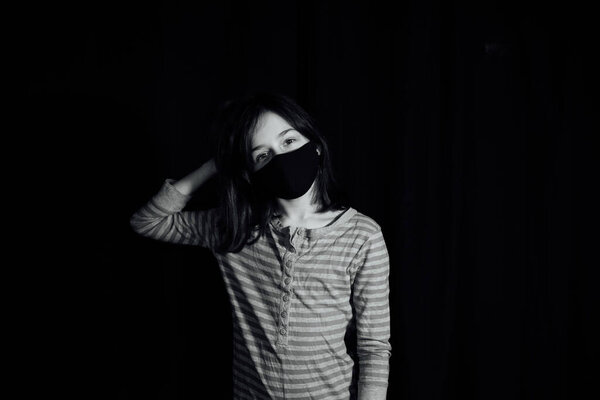 Girl in a medical protective mask. Coronavirus epidemic. Conceptual image. Symbol. Stop the virus. Protective equipment. Girl 9 years old in a medical mask. Virus. Bacteria. Teenager in red clothes