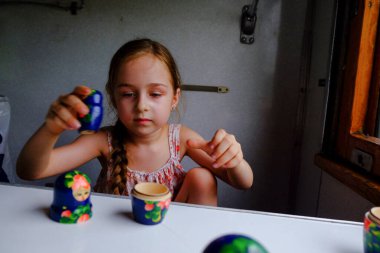 Trendeki tatlı kız. Yaz Tatili ve Seyahat Konsepti. 5-6 yaşlarında bir kız trene biniyor. Gençler seyahat eder. Uzun saçlı küçük kız. Çocuk portresi