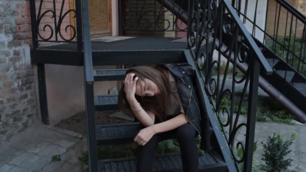 一个年轻女孩的画像 这个漂亮时髦的女孩坐在乡村房屋的门槛上 女孩坐在屋前门廊的台阶上 一个女人坐在门口的台阶上 — 图库视频影像