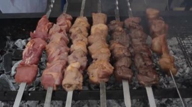 Dumanlı ızgarada marine edilmiş domuz etli shashlik. Izgarada kızartılmış barbekü. Açık ızgarada leziz kebap, açık mutfak. Şehirde yemek festivali. Lezzetli yemekler şiş şiş, yemek katında kızartılıyor.