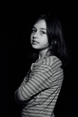 9 yaşında, siyah arkaplanlı, portre şeklinde bir çocuk portresi. Siyah arka planda 9 yaşında bir kız.