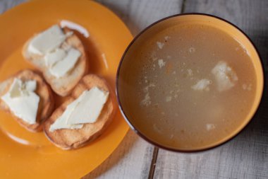Makarnalı tavuk çorbası. Makarna çorbası, ekmek ve tereyağı.