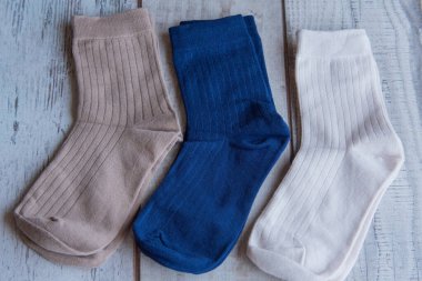 Güzel forma çorapları. Yukarıdan bak. Ahşap bir arka planda bir sürü çorap. Farklı renkte çoraplar ve desenler. Soğuk mevsimler için kıyafetler. Örgü elbise. Süslü çoraplar..