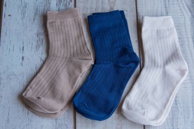 Güzel forma çorapları. Yukarıdan bak. Ahşap bir arka planda bir sürü çorap. Farklı renkte çoraplar ve desenler. Soğuk mevsimler için kıyafetler. Örgü elbise. Süslü çoraplar..