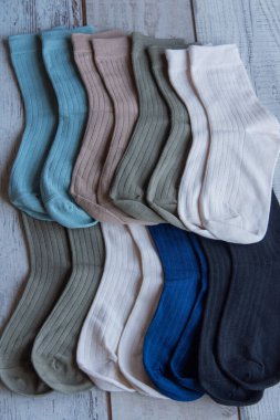 Güzel forma çorapları. Yukarıdan bak. Ahşap bir arka planda bir sürü çorap. Farklı renkte çoraplar ve desenler. Soğuk mevsimler için kıyafetler. Örgü elbise. Süslü çoraplar..