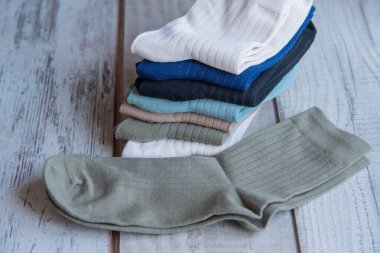 Güzel forma çorapları. Yukarıdan bak. Ahşap bir arka planda bir sürü çorap. Farklı renkte çoraplar ve desenler. Soğuk mevsimler için kıyafetler. Örgü elbise. Süslü çoraplar..