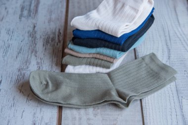 Güzel forma çorapları. Yukarıdan bak. Ahşap bir arka planda bir sürü çorap. Farklı renkte çoraplar ve desenler. Soğuk mevsimler için kıyafetler. Örgü elbise. Süslü çoraplar..