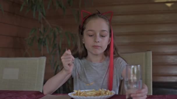 ファーストフード店でフライドポテトを食べる少女 女の子はフライドポテトを食べる 女の子はカフェで昼食をとる — ストック動画