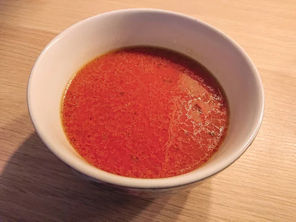 Weiße Keramikschale gefüllt mit einer gesunden roten Tomatensuppe — Stockfoto