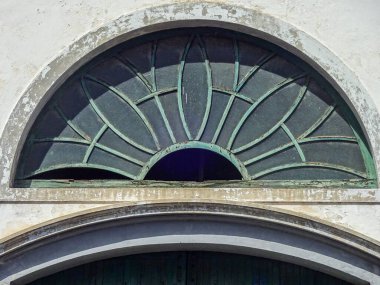 Eski beyaz Akdeniz İspanyol evindeki klasik yeşil kapı ve yuvarlak pencere.