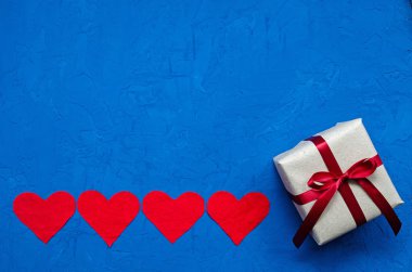 sıfır atık konsepti. Çevre dostu keten kalpler küçük olandan hediyeye mavi arka planda. Sevgililer Günü, doğum günü ya da diğer tatiller için tebrikler. yatay yönelim