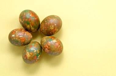 Sağ çerçevede mermer modern moda Paskalya yumurtaları. Sarı arka planda çiçek şeklinde. Fotokopi alanı da var. Paskalya ve bahar konsepti