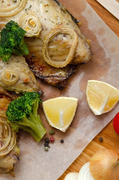 Closeup macrou proaspăt coapte licitație cu inele de ceapă tocată, broccoli și lămâie pe o placă de tăiere din lemn închis în hârtie de copt. dieta keto și flexitariană și alimentația sănătoasă — Fotografie, imagine de stoc