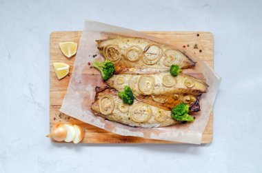 Fırında taze uskumru, doğranmış soğan, brokoli ve limonlu halkalar ve fırın kağıdında hafif bir zemin. Keto, esnek beslenme ve sağlıklı beslenme. kopyalama alanı ile