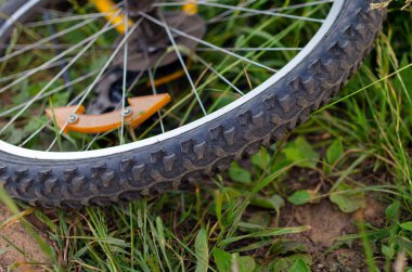 Yeşil çimlerin üzerinde duran sarı bisiklet tekerleğinin yakın çekim koruyucuları. sağlıklı yaşam tarzı konsepti. Piknik tatilini ve hafta sonunu iptal et. doğada dinlen.