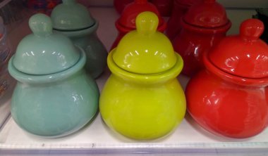 Beyaz zemin üzerinde yeşil, kırmızı, mavi seramik şeker kasesi.