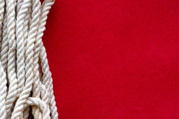Närbild av ett rep på röd bakgrund. utrymme för text. — Stockfoto
