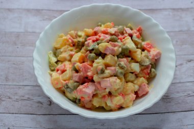 Ev pişirme cam bir kase içinde Olivier sebze salatası, closeup fotoğraf.