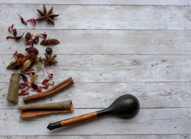 Gül yapraklı doğal çay kompozisyonu. Ahşap bir kaşıkta gül yapraklarının Macro fotoğrafı. İçinde çiçek ve gül çayı bulunan çay ahşap bir tahtanın üzerinde..