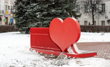 Parkta sahte elementler olan bir bankın arkasında kırmızı kalpler.