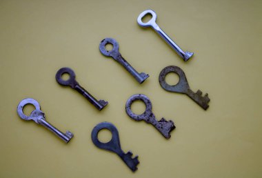 Beyaz arka planda beş eski anahtar üst üste dizilmiş. Yukarıdan görüntüle, dikey fotoğraf, izole edilmiş ev anahtarları.