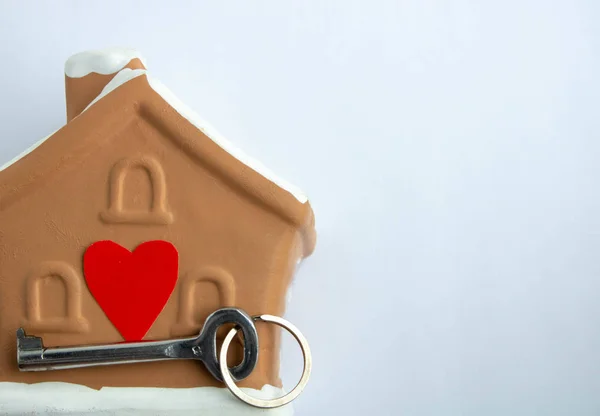 Casa marrón corazón y llave sobre un fondo blanco. Sumbol de familia y amor. Espacio para texto . —  Fotos de Stock