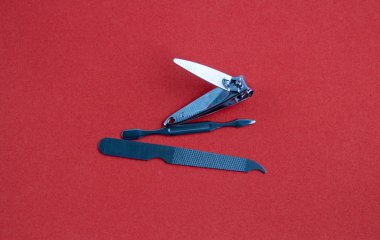 Kırmızı arkaplanda bir manikür seti araçları