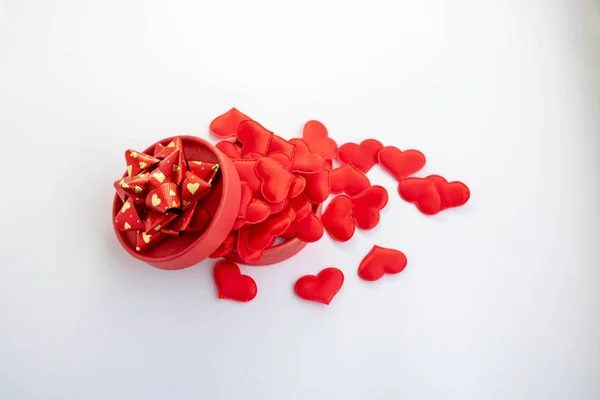 Round red festive gift box on white background. Red hearts. Holiday card. View from above. Flat lay