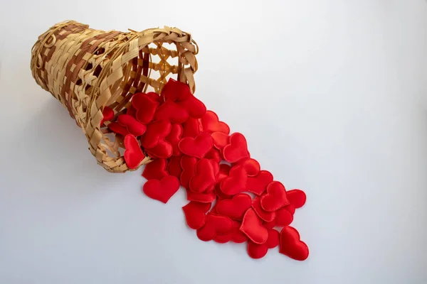 Small hearts in a wicker heart-shaped basket isolated on white. Close-up view. the concept of love and romance — 图库照片