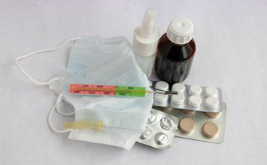 İlaç hapları, koruyucu maske, beyaz arka planda izole edilmiş şırınga ve termometre. Solunum hastalıkları tedavisinin tıp konsepti. Hastalık önleme. Coronavirus tedavisi kavramı.