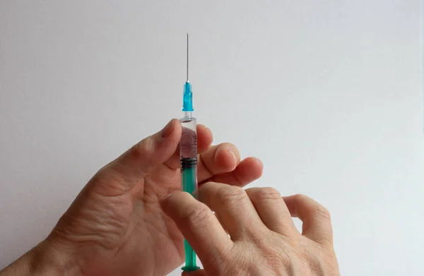 Общие предварительно заполненные шприцы от вакцины. Мужская рука держит шприц с вакциной — стоковое фото