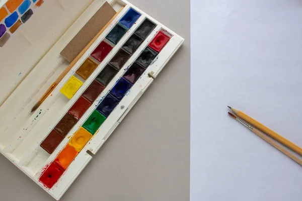 Komposition aus Kunstmaterialien. Aquarell. Aquarellfarben. Stretching Farbe Farben. Kunstmaterialien. Mehrfarbige Farben. Pinsel und Farbe. Bleistifte und Pinsel. Blatt Aquarellpapier — Stockfoto