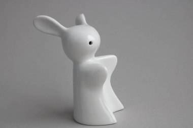 Renkli gri arkaplandaki beyaz Paskalya tavşanının üst görünümü.